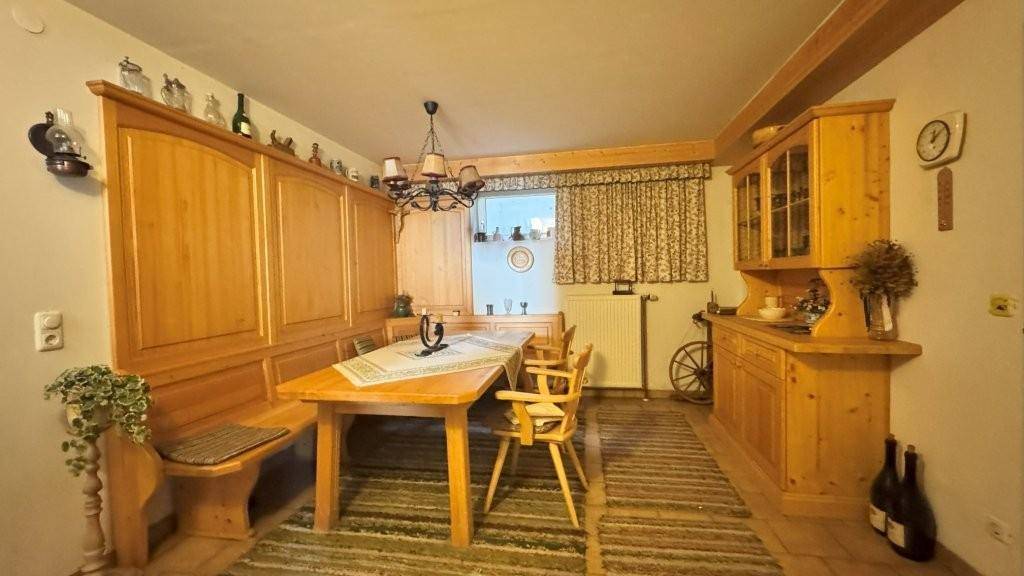 Rustikaler Essbereich mit Holztisch, Eckbank und passenden Schränken, traditionell eingerichtet.