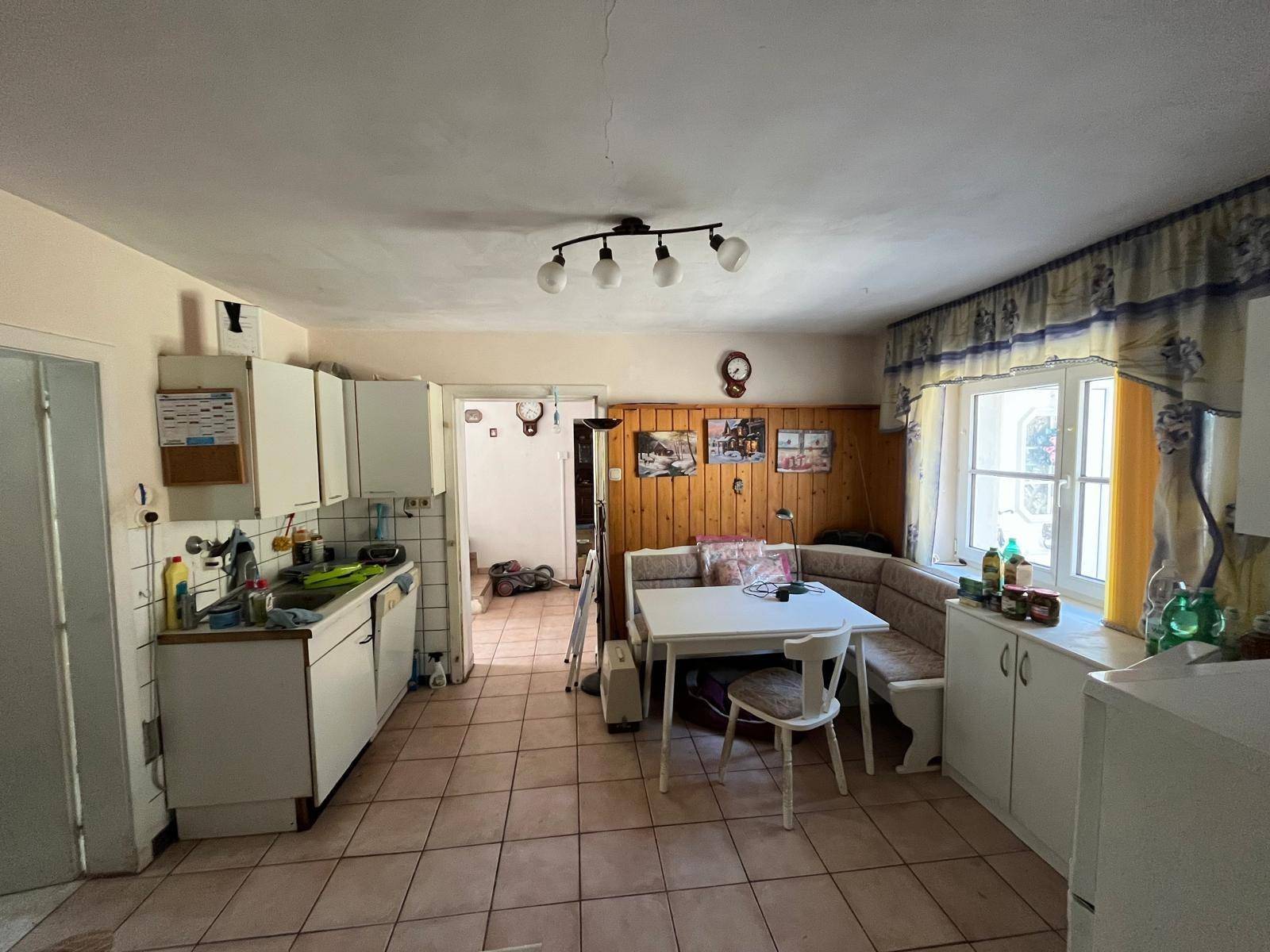 Wohnküche mit Essbereich, Holzvertäfelung und gefliestem Boden in traditionellem Stil.