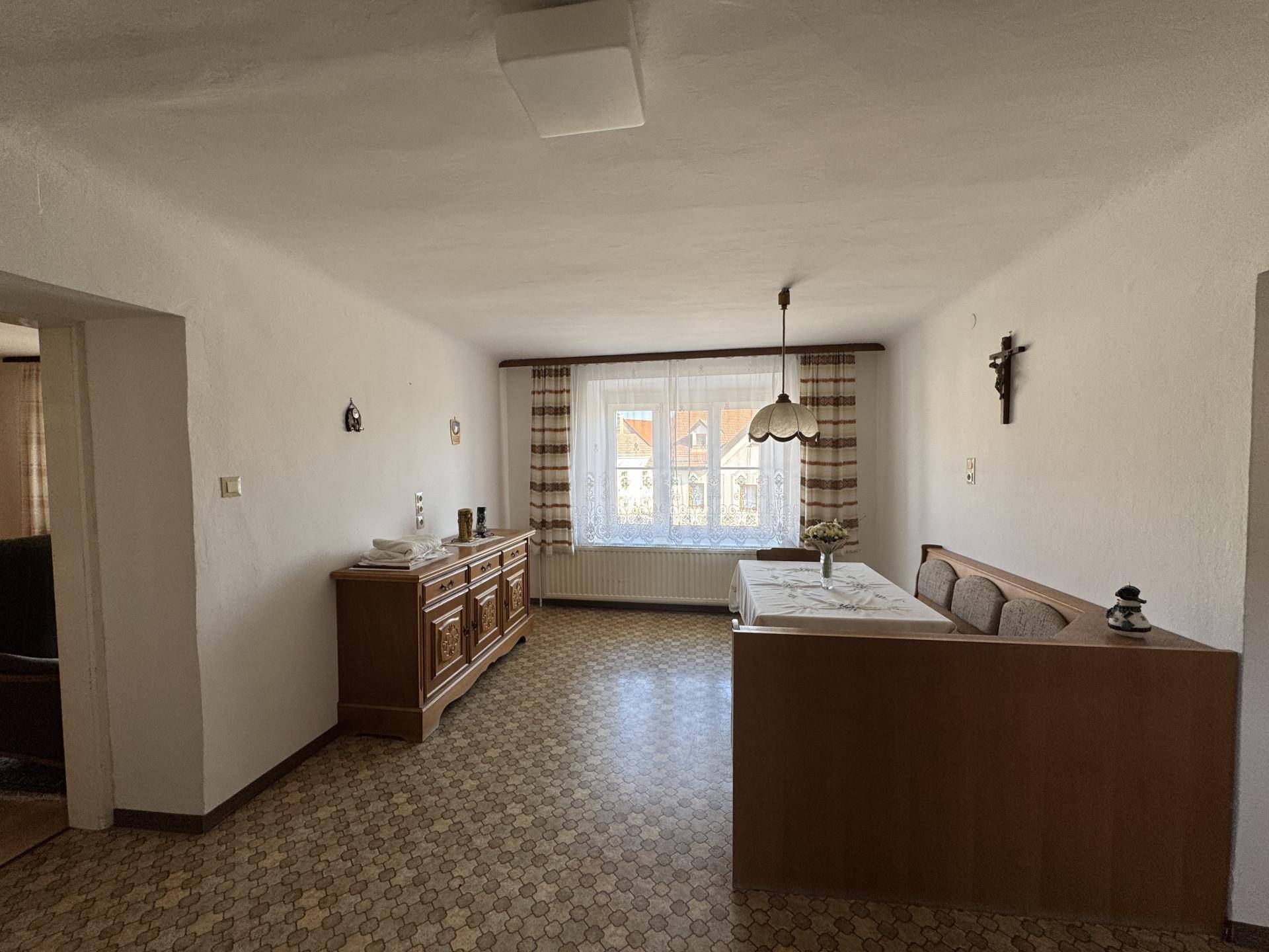 Gemütlicher Essbereich mit Holztisch, Eckbank und Blick auf die umliegenden Häuser.