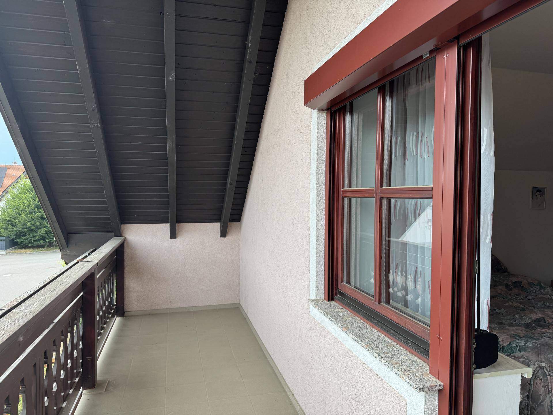 Balkon mit Holzgeländer und Blick auf die Umgebung.