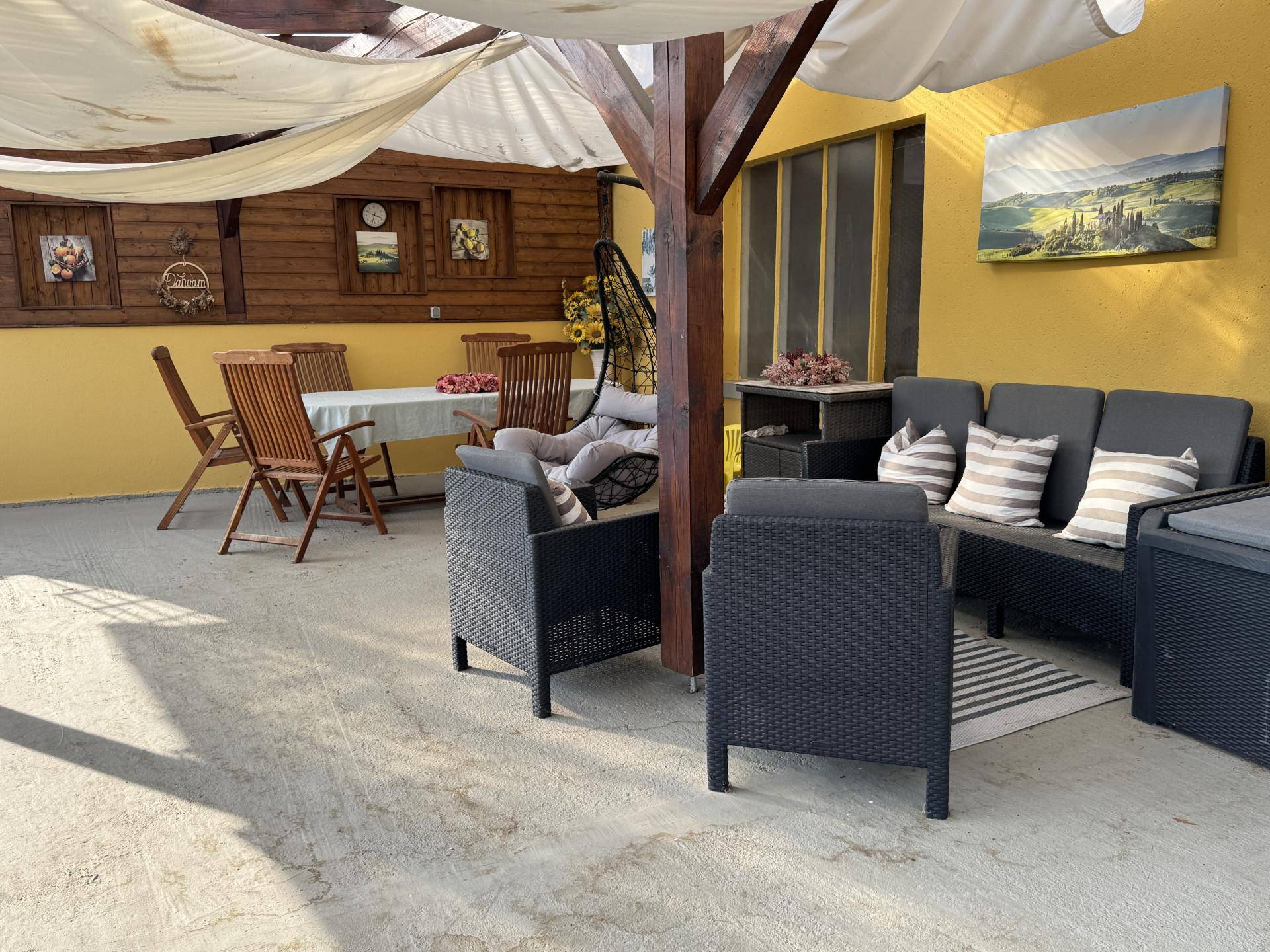 Gemütliche Terrasse mit Sitzgelegenheiten, Esstisch und Sonnenschutz für entspannte Stunden.