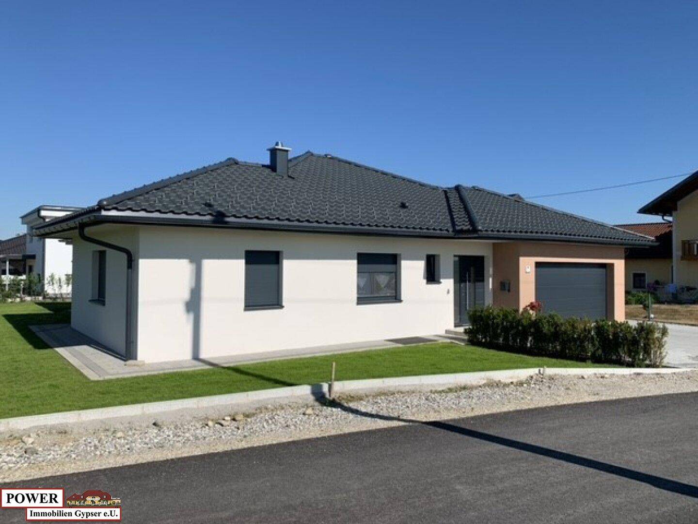 Modernes Einfamilienhaus mit integrierter Garage, gepflegtem Vorgarten und Zufahrt.