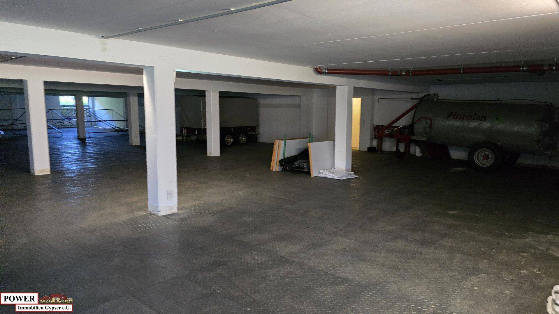 Geräumiger Untergeschossbereich mit Betonboden und sichtbaren Säulen, der Platz für Fahrzeuge und Lagerung bietet.