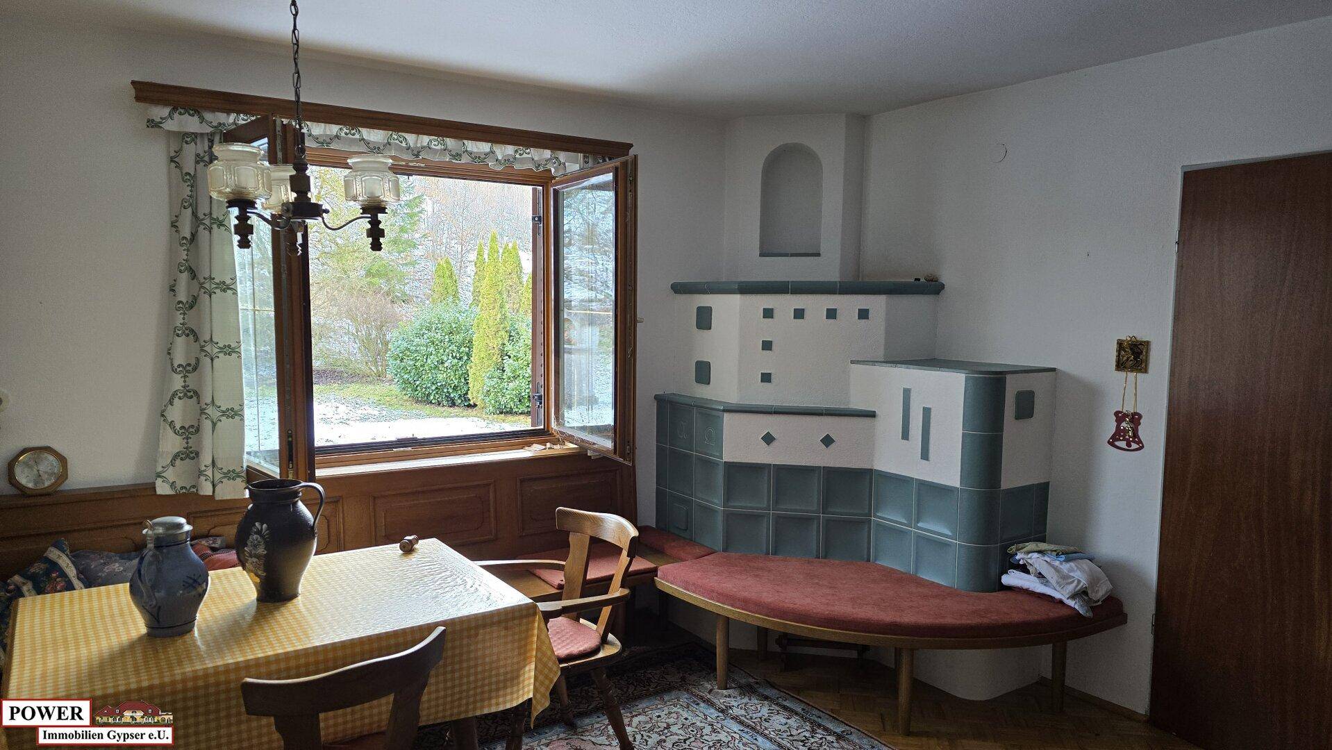 Traditioneller Essbereich mit einem Kachelofen und Holzbänken, ideal für gemütliche Stunden.