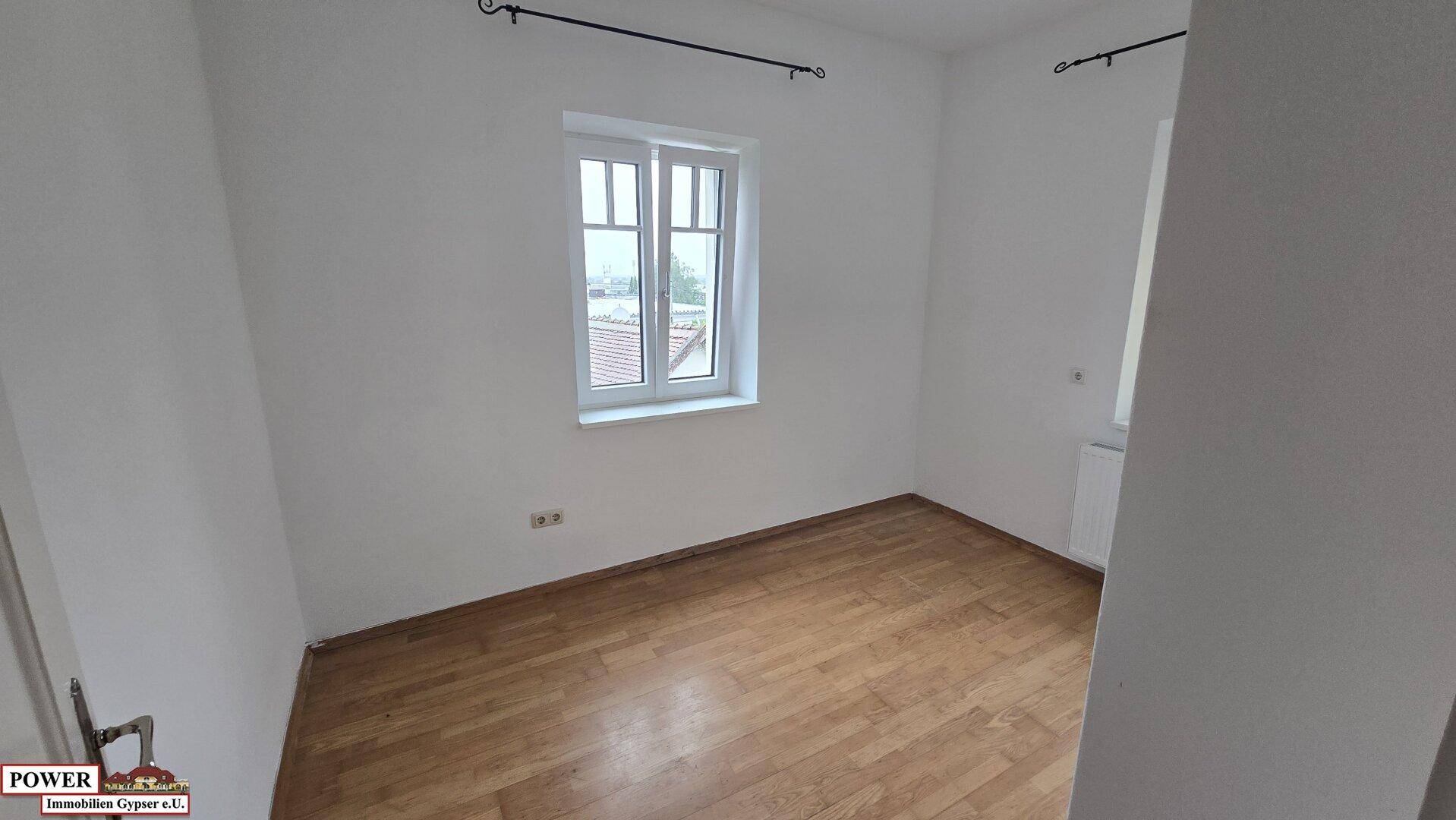 Kleineres Zimmer mit Parkettboden und einem Fenster, das für ausreichend Helligkeit sorgt.