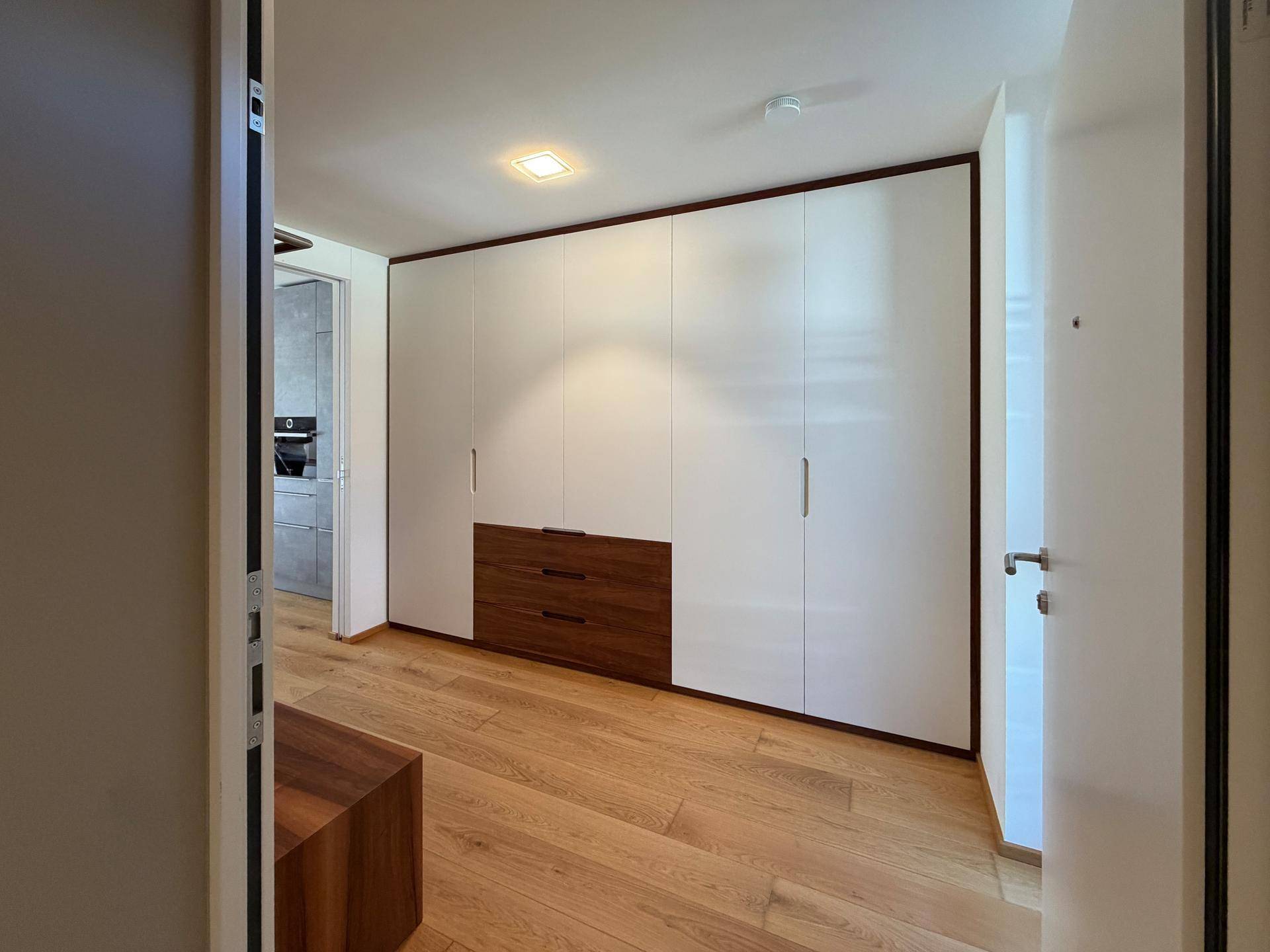Heller Eingangsbereich mit modernen Einbauschränken und hochwertigem Holzfußboden.