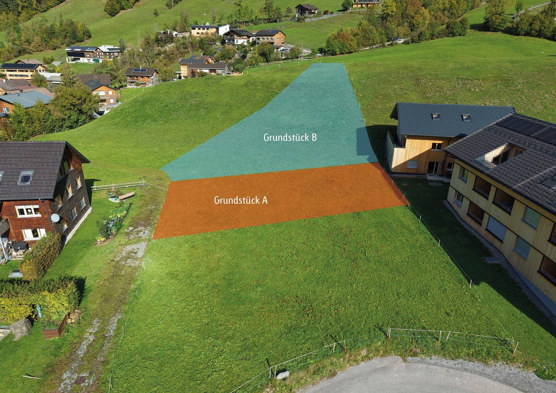 Luftbild der Grundstücke A und B, eingebettet in eine grüne Hügellandschaft mit umliegenden Häusern.