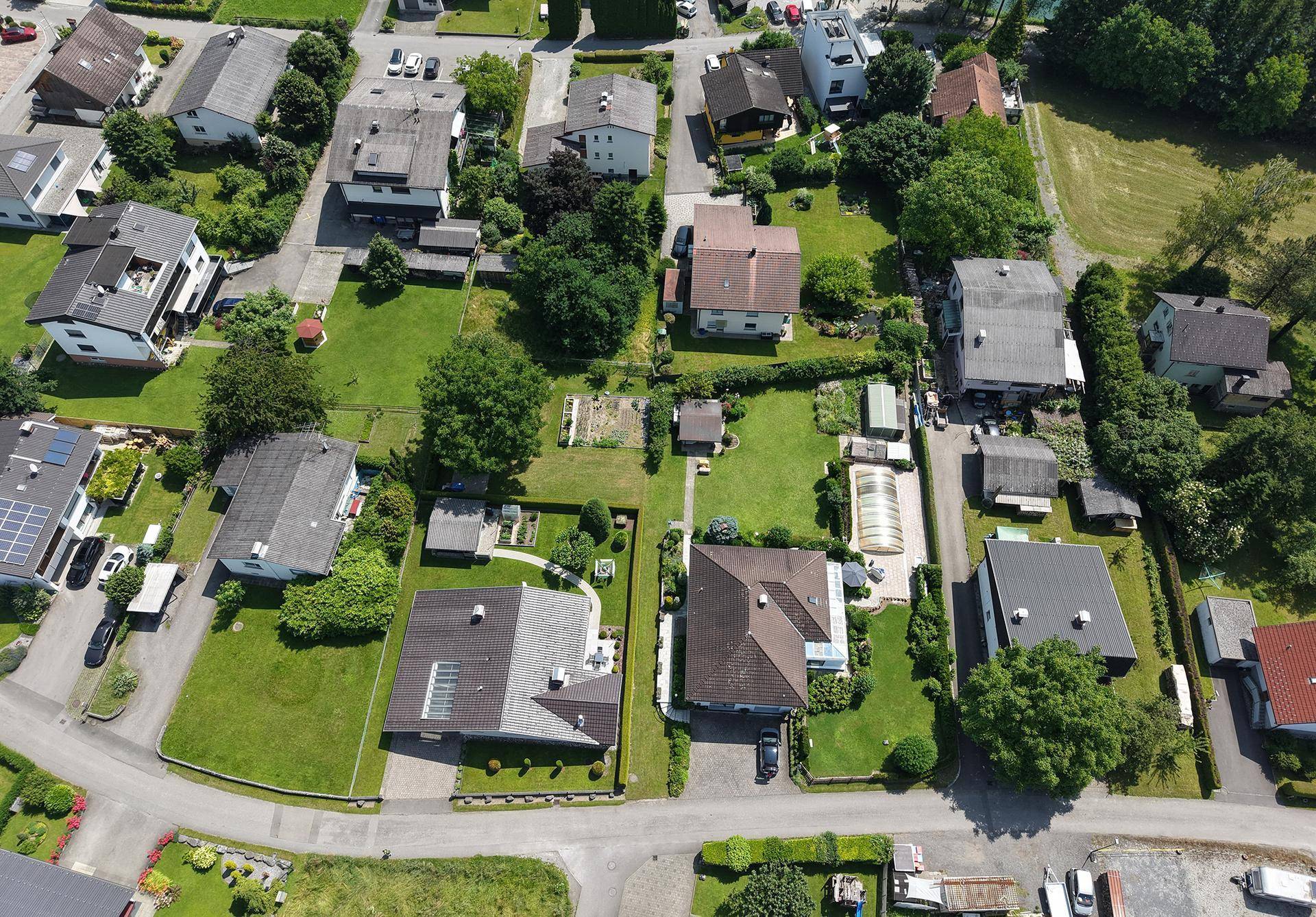 Weitläufige Luftaufnahme eines ruhigen Wohnviertels mit vielen Einfamilienhäusern und Gärten.