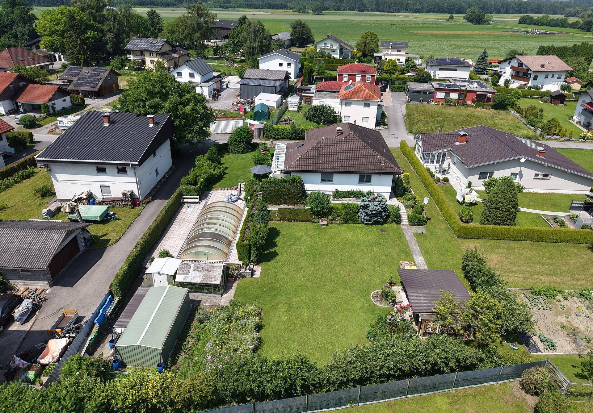 Haus mit großem Garten, überdachtem Pool und Blick auf die umliegende Landschaft.