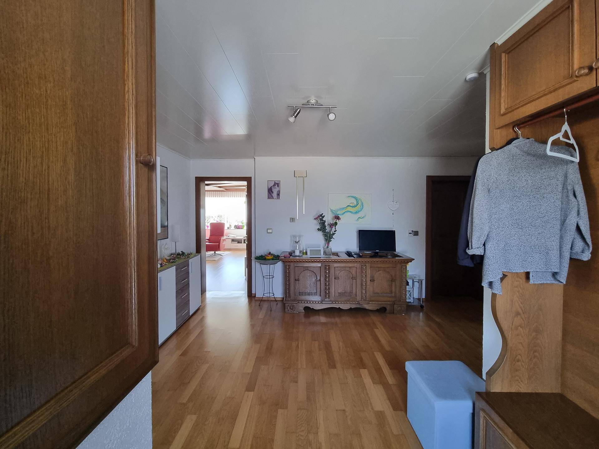 Eingangsbereich mit Holzmöbeln, Garderobe und Parkettboden.