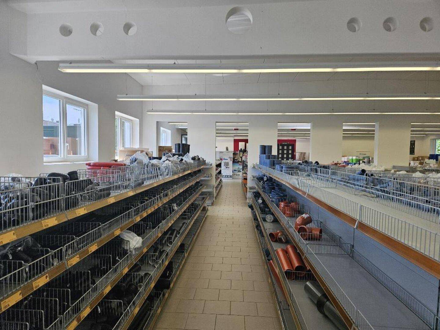 Weiterer Bereich des Verkaufsraums mit Regalen, die verschiedene Produkte und Materialien präsentieren.