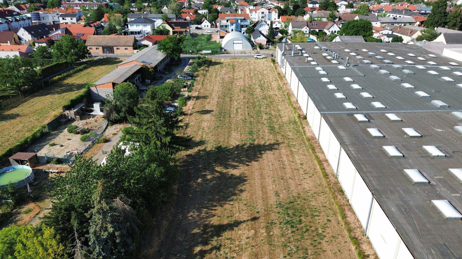 Luftbild eines weitläufigen Grundstücks, umgeben von Industriegebäuden und einer Wohnsiedlung.