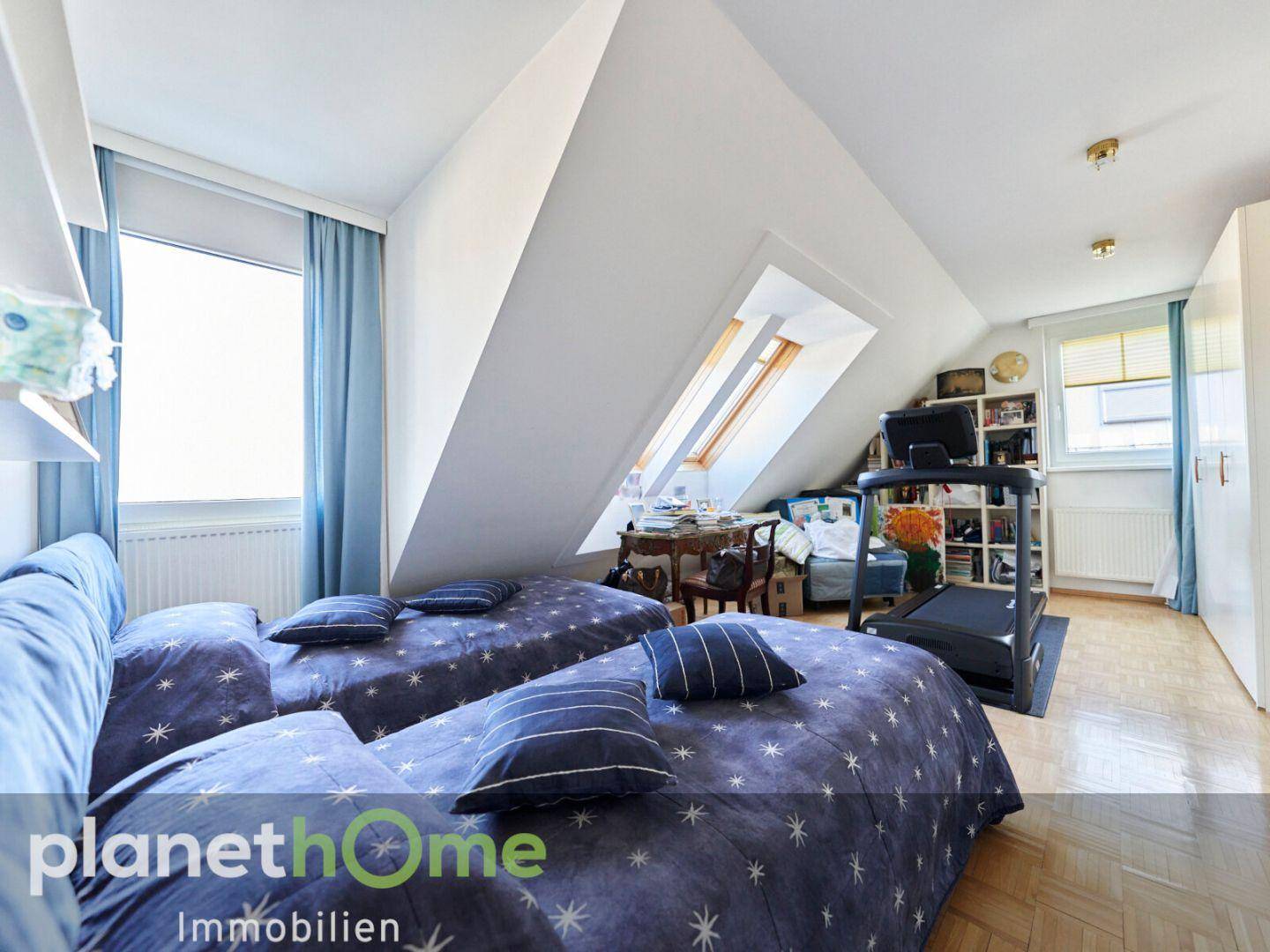 Helles Schlafzimmer mit zwei Betten, Dachschrägen und einem Laufband.