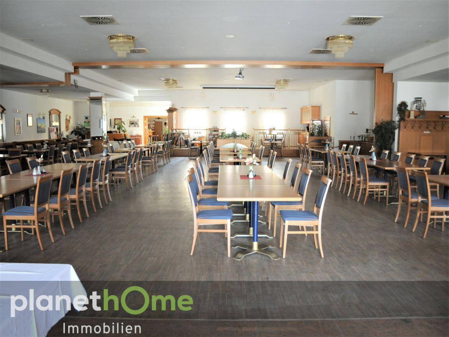 Geräumiger Speisesaal mit Holztischen und Stühlen, bereit für den täglichen Restaurantbetrieb.