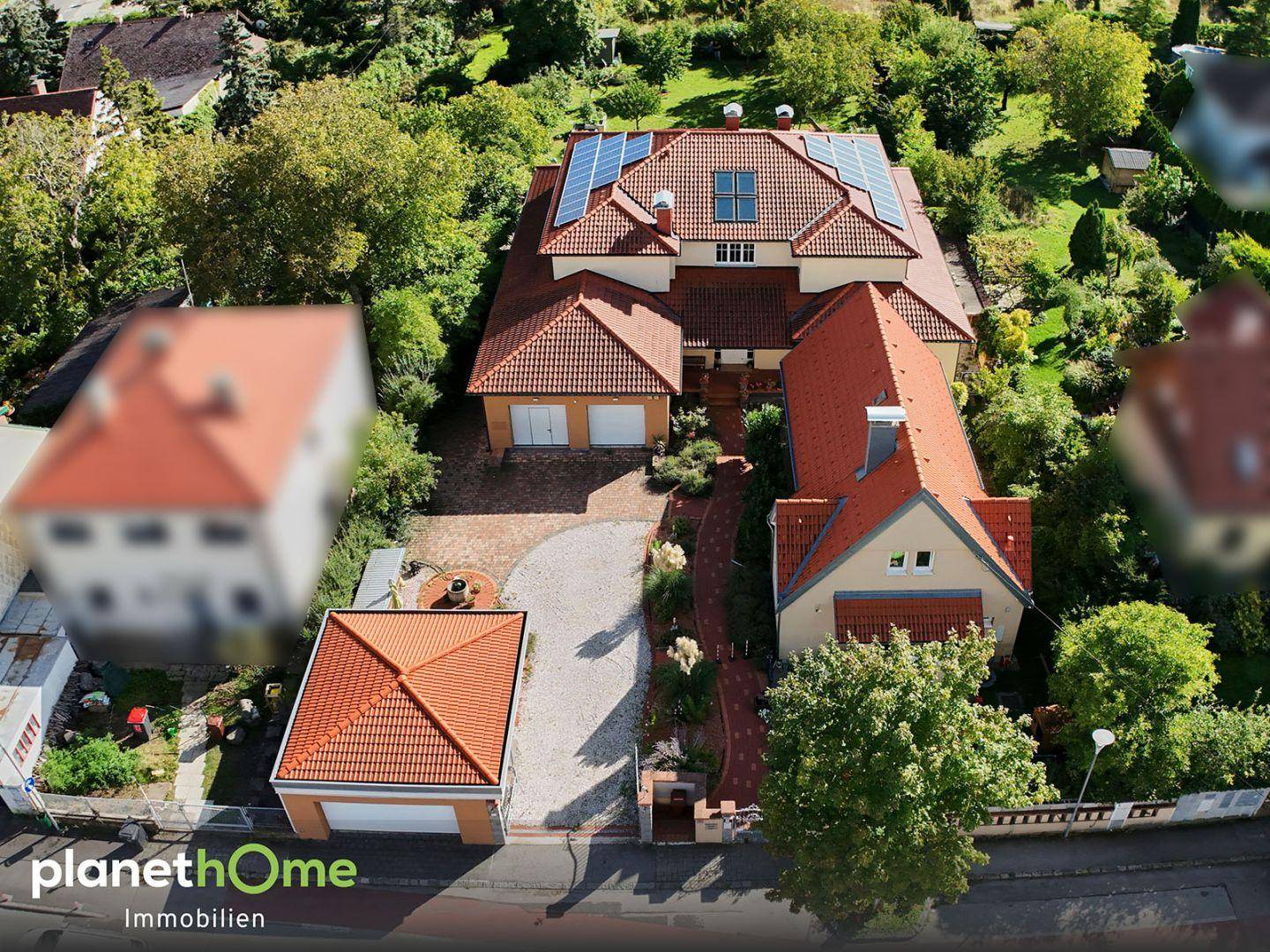 Vogelperspektive des weitläufigen Grundstücks mit Haupthaus, Nebengebäuden und Solaranlage.