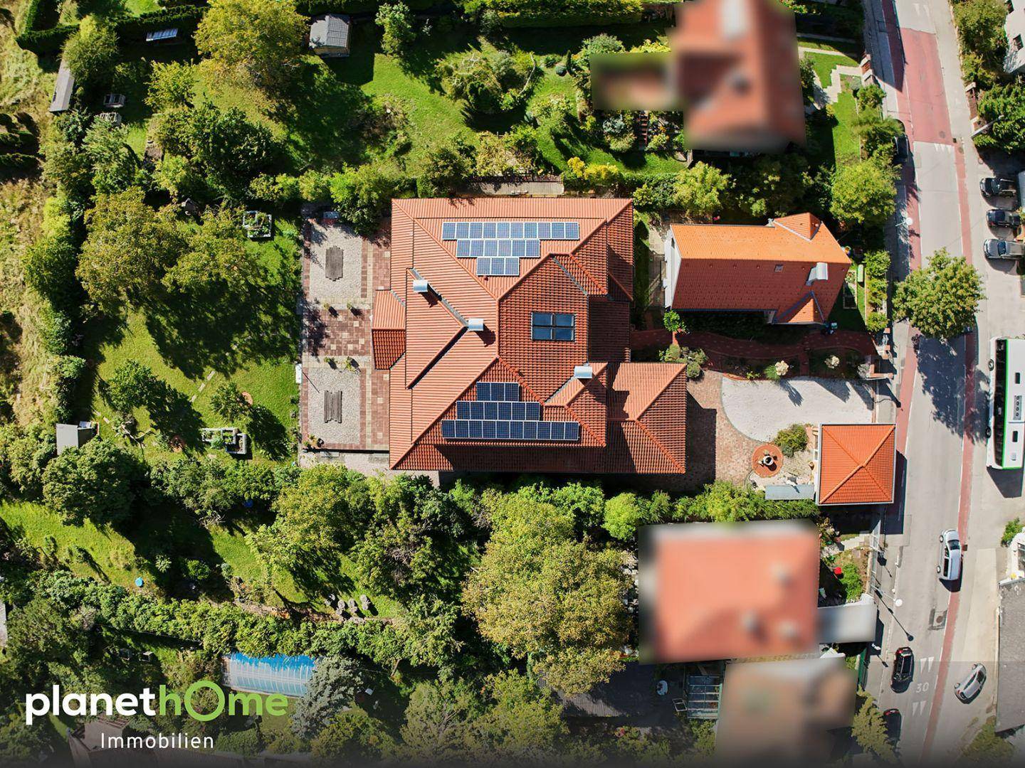 Luftaufnahme des Anwesens mit Solaranlage auf dem Dach und großem Garten.