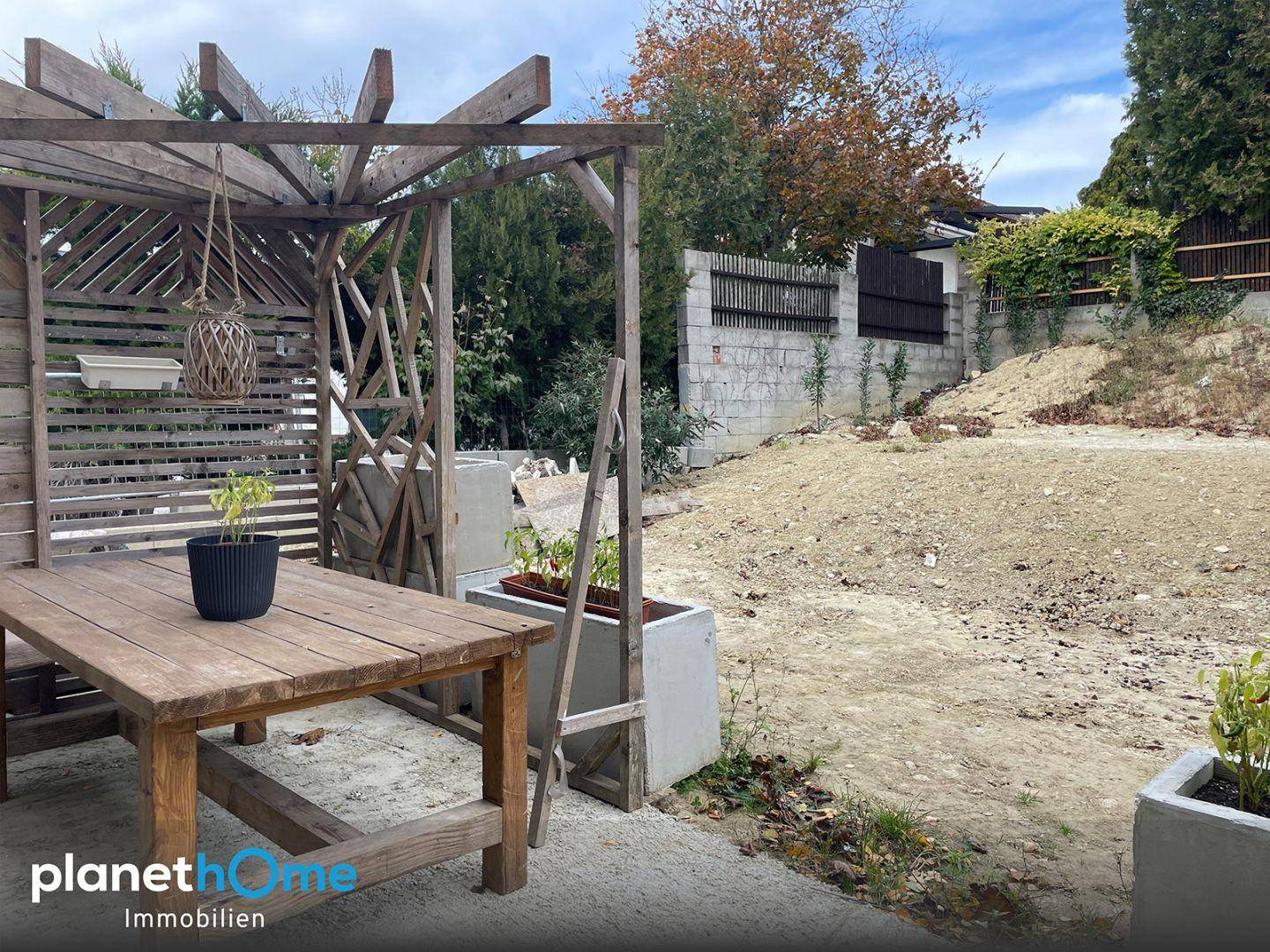 Gartenbereich mit Holzpergola und unfertiger Landschaftsgestaltung, bereit für die Gestaltung.