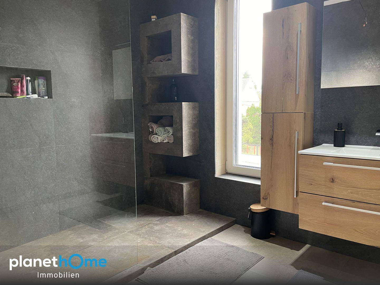 Modernes Badezimmer mit begehbarer Dusche, Holzschränken und Fenster für Tageslicht.