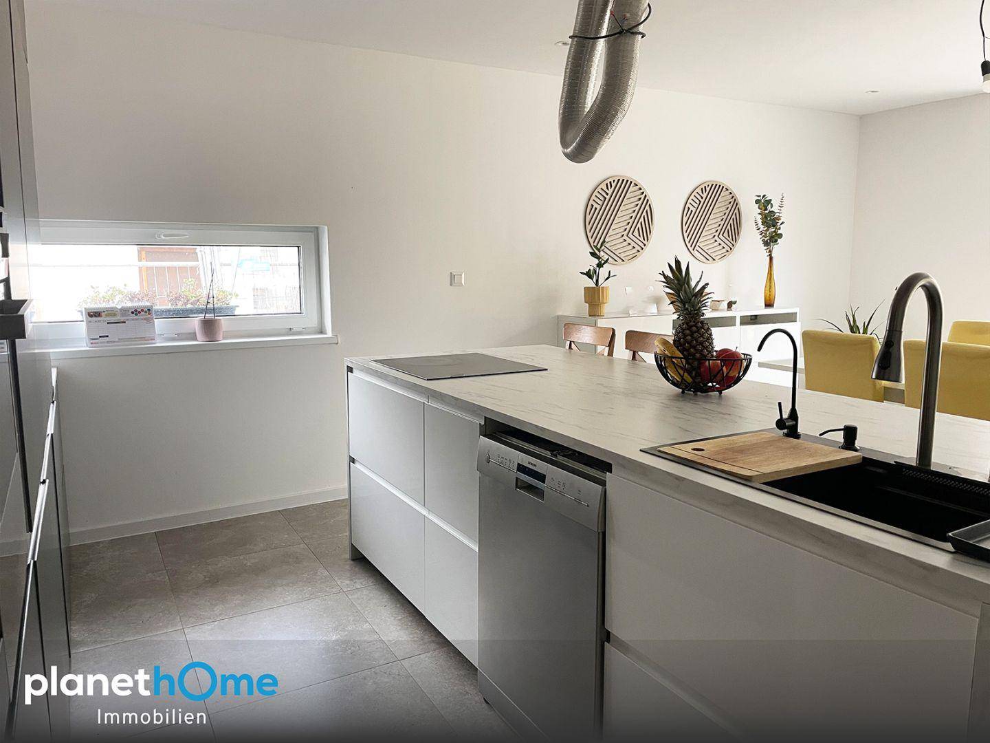 Moderne Küche mit Kücheninsel, integriertem Geschirrspüler und Fenster über der Arbeitsfläche.