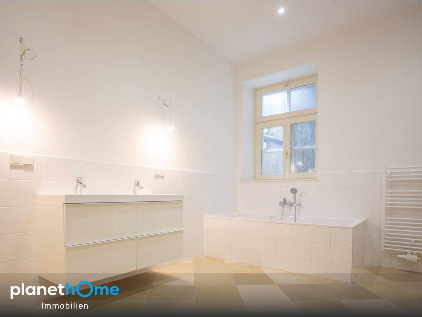 Modernes Badezimmer mit Doppelwaschbecken, Badewanne und beheiztem Handtuchhalter.