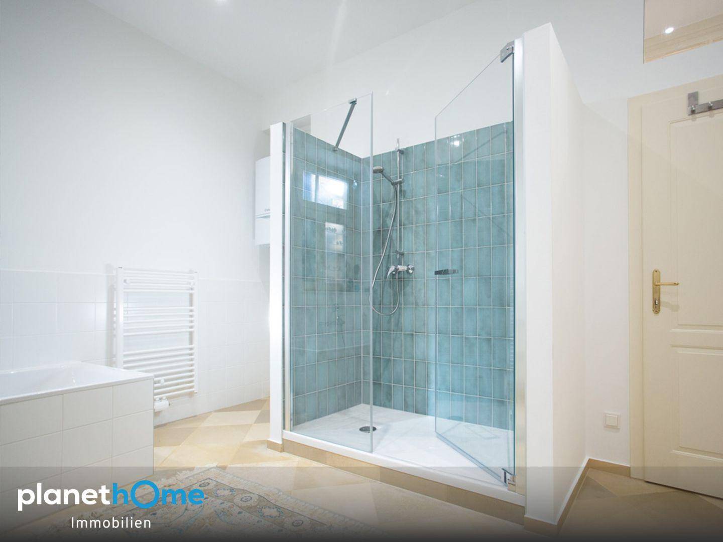 Modernes Badezimmer mit geräumiger begehbarer Dusche und hellen Fliesen.