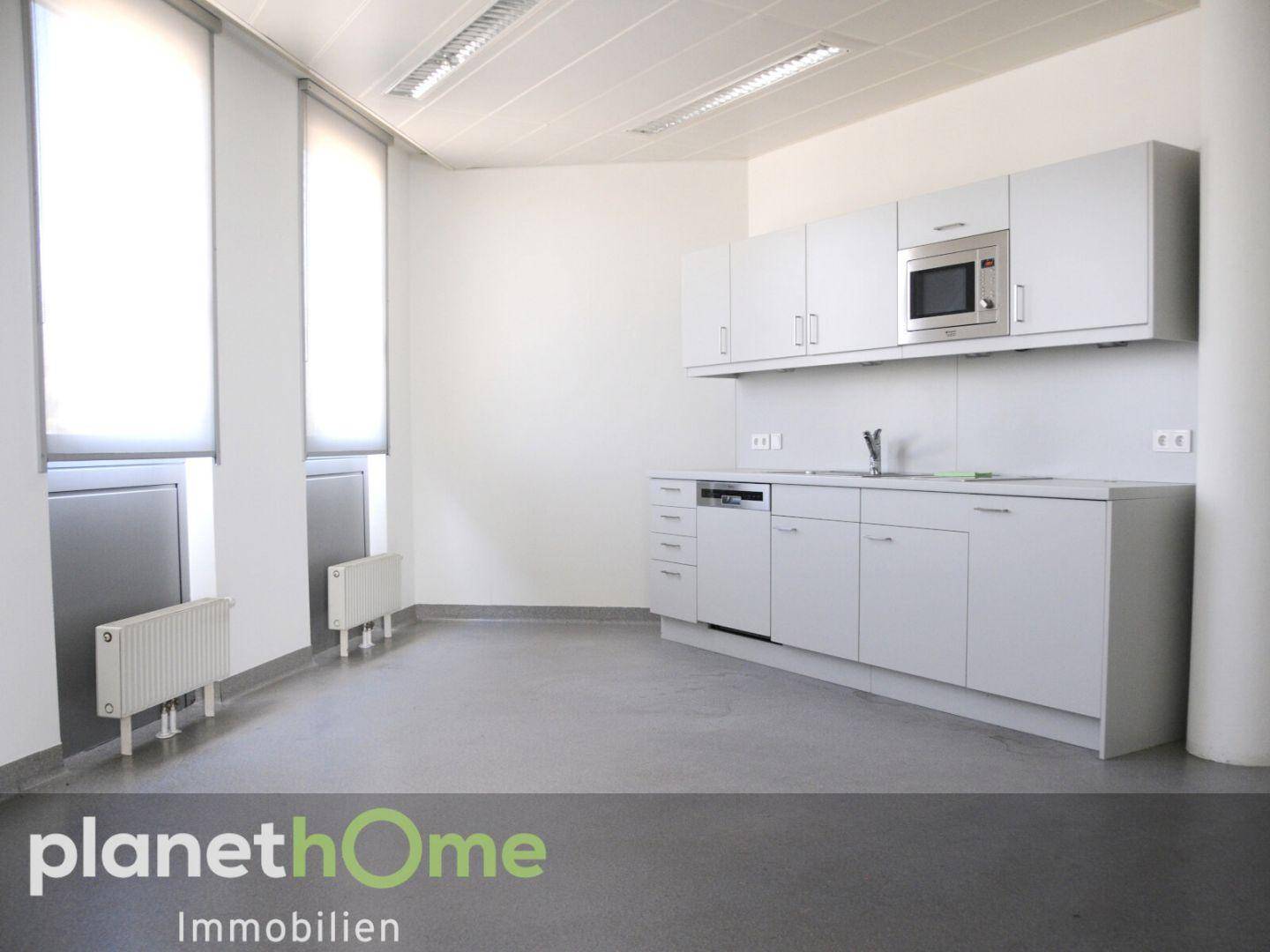 Funktionale Küchenzeile mit Spülmaschine und Mikrowelle, ideal für Pausenräume in Büros.