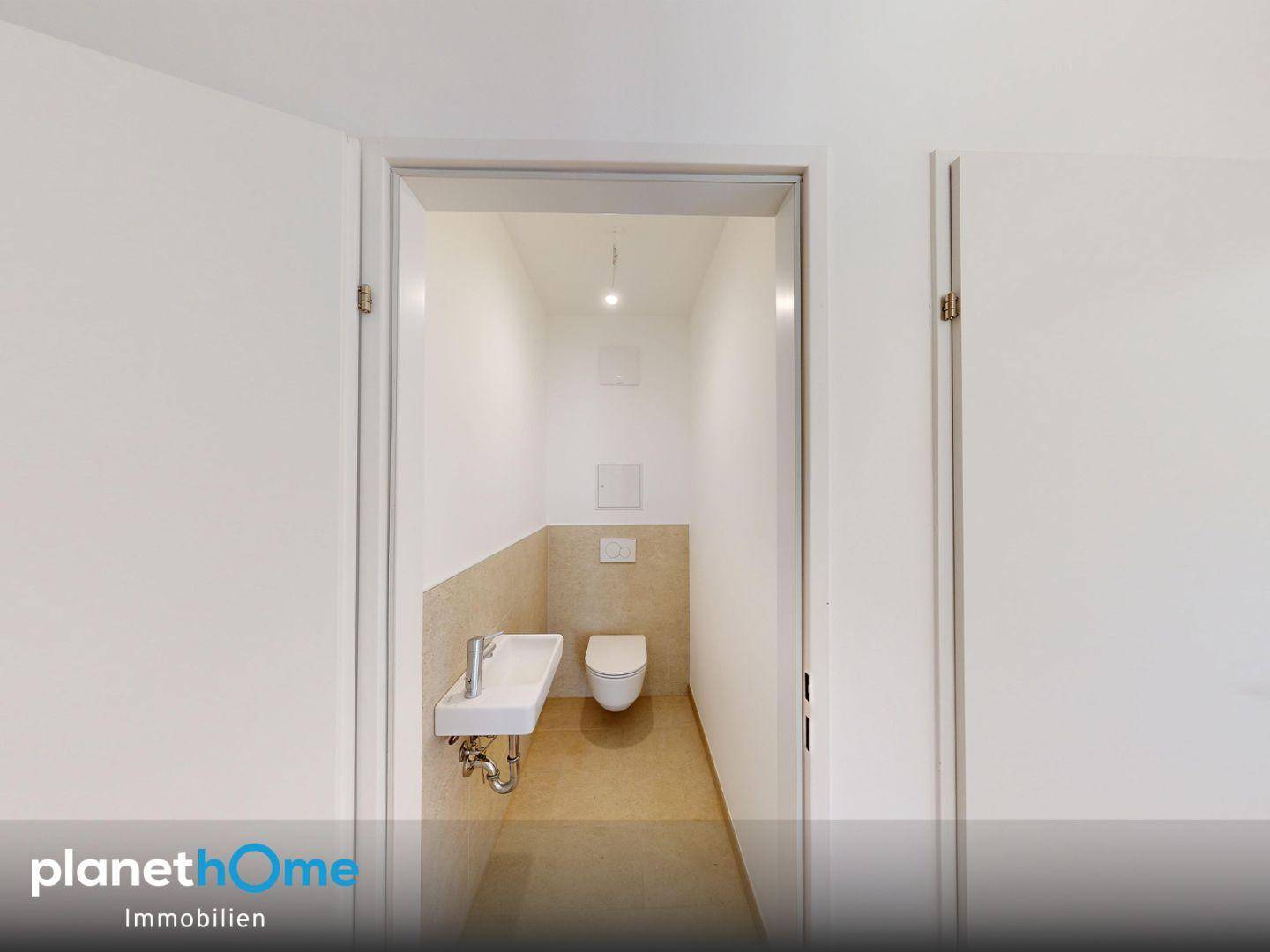 Kleines Gäste-WC mit wandhängender Toilette und modernem Waschbecken.