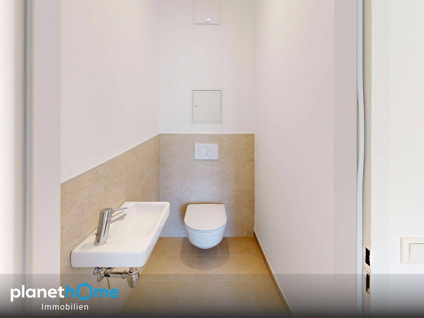Kompaktes Gäste-WC mit wandhängender Toilette und kleinem Handwaschbecken.