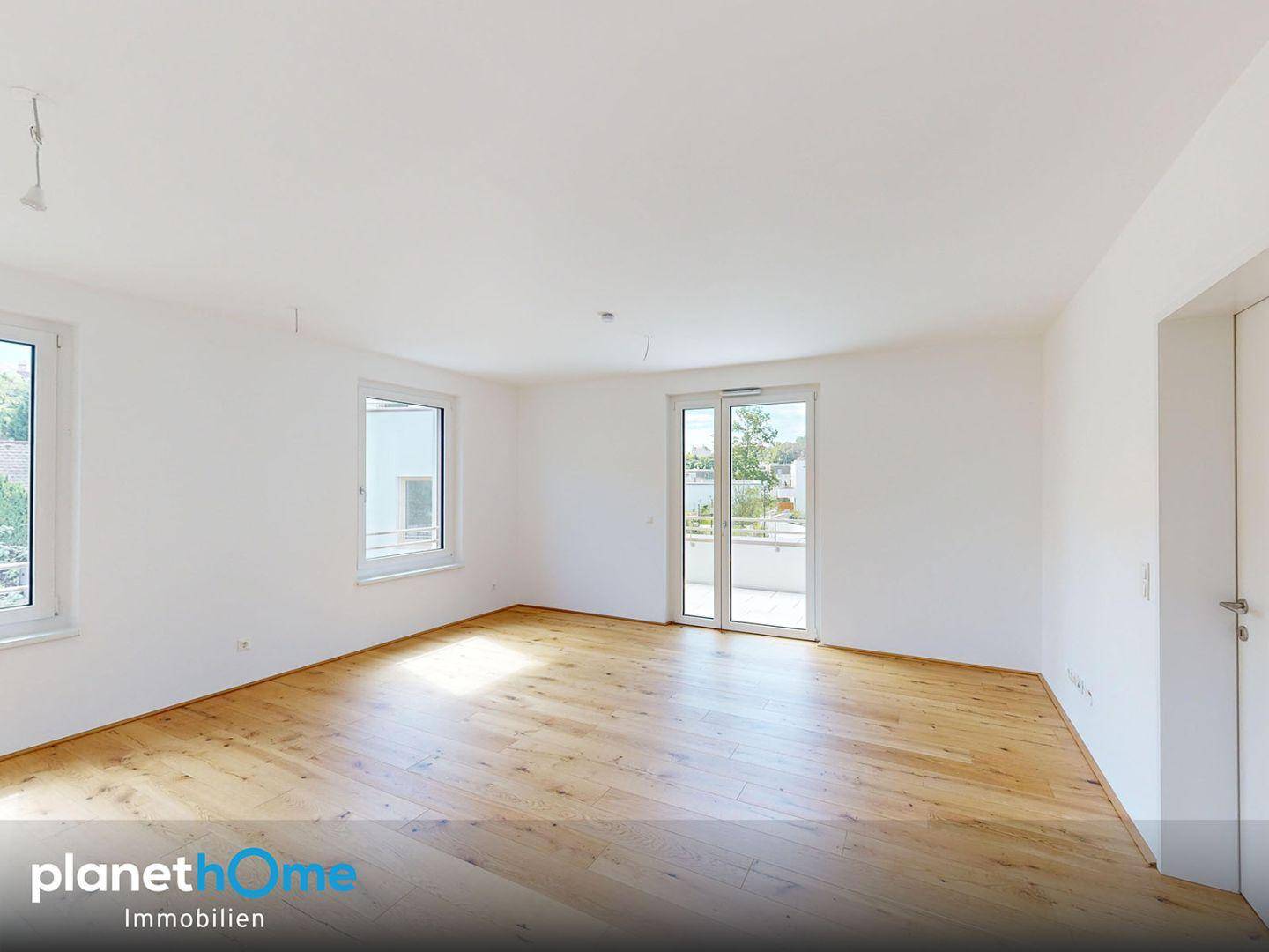 Geräumiges, helles Zimmer mit Holzboden und Zugang zu einem Badezimmer, bereit zur individuellen Gestaltung.