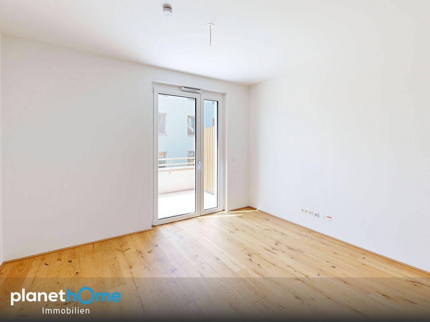 Heller Raum mit Holzboden und Zugang zu einem Balkon, ideal für individuelle Gestaltung.