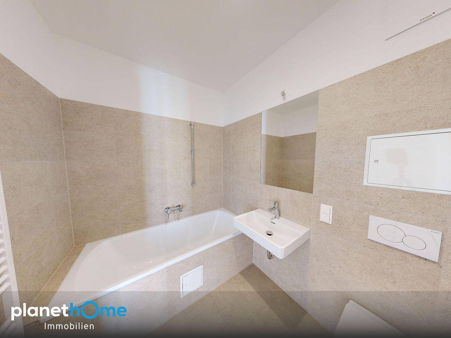 Modernes Badezimmer mit Badewanne, Wand-WC und beigefarbenen Fliesen.