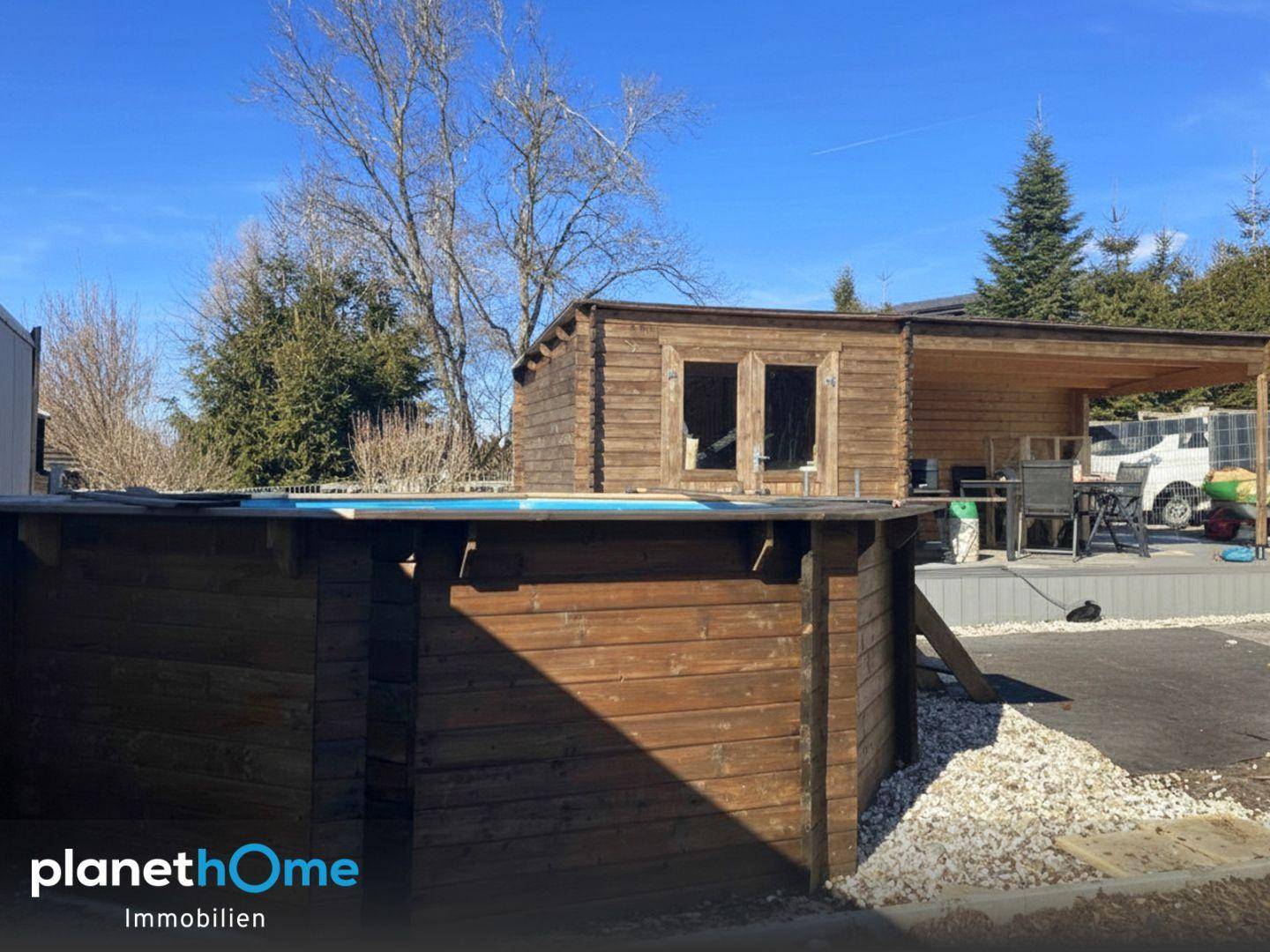 Gartenbereich mit Holzterrasse, überdachtem Sitzplatz und einem Aufstellpool.
