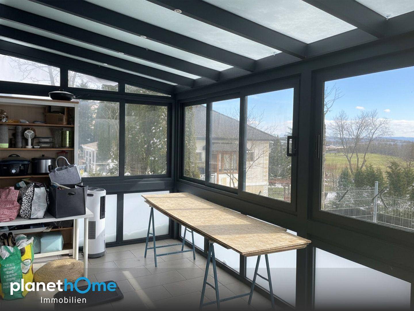 Wintergarten mit weitem Blick über die Landschaft und viel Tageslicht.