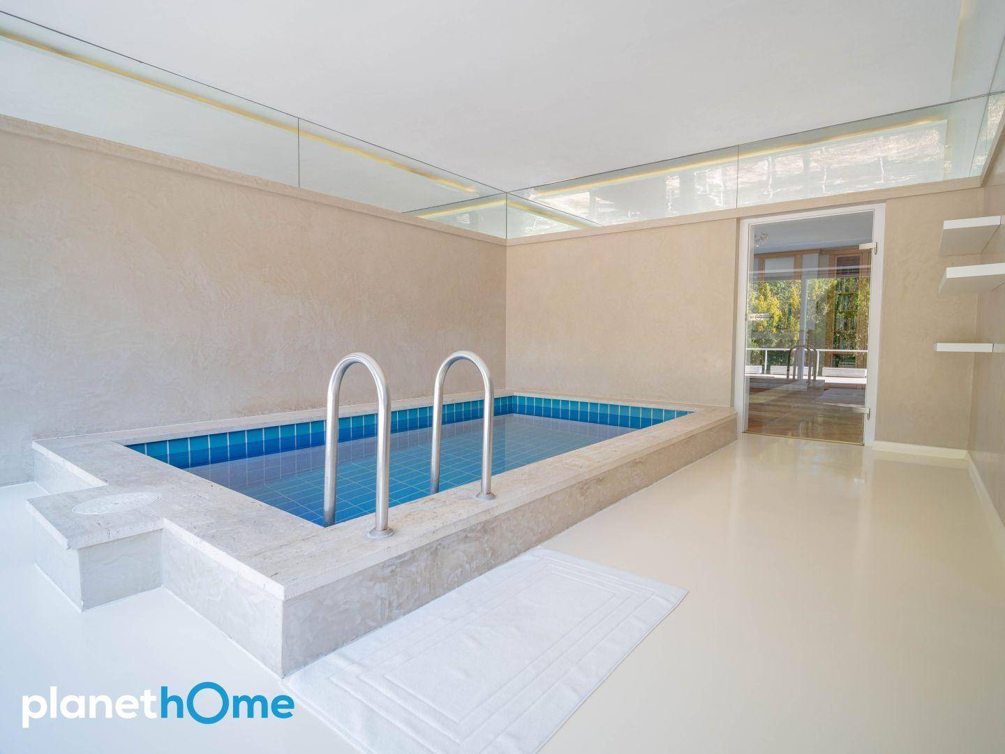 Eleganter Innenpoolbereich mit blauen Fliesen und minimalistischem Design.