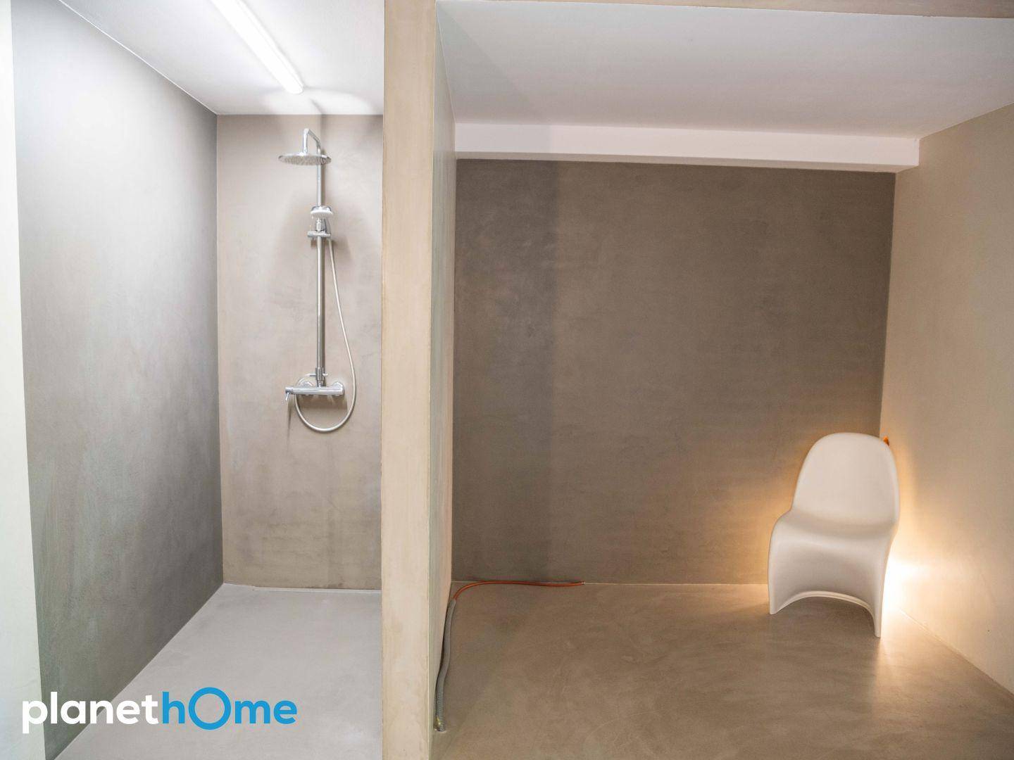 Moderne Duschkabine mit minimalistischem Design und grauen Wänden.