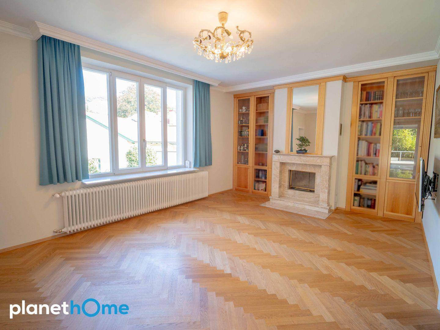 Klassisches Wohnzimmer mit Kamin, Einbauschränken und Parkettboden.