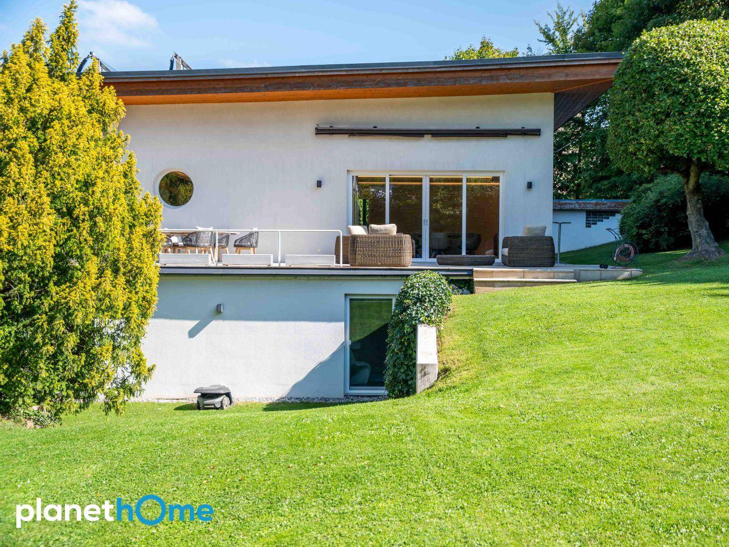 Rückseite des Hauses mit großem Garten und Zugang zum Untergeschoss.
