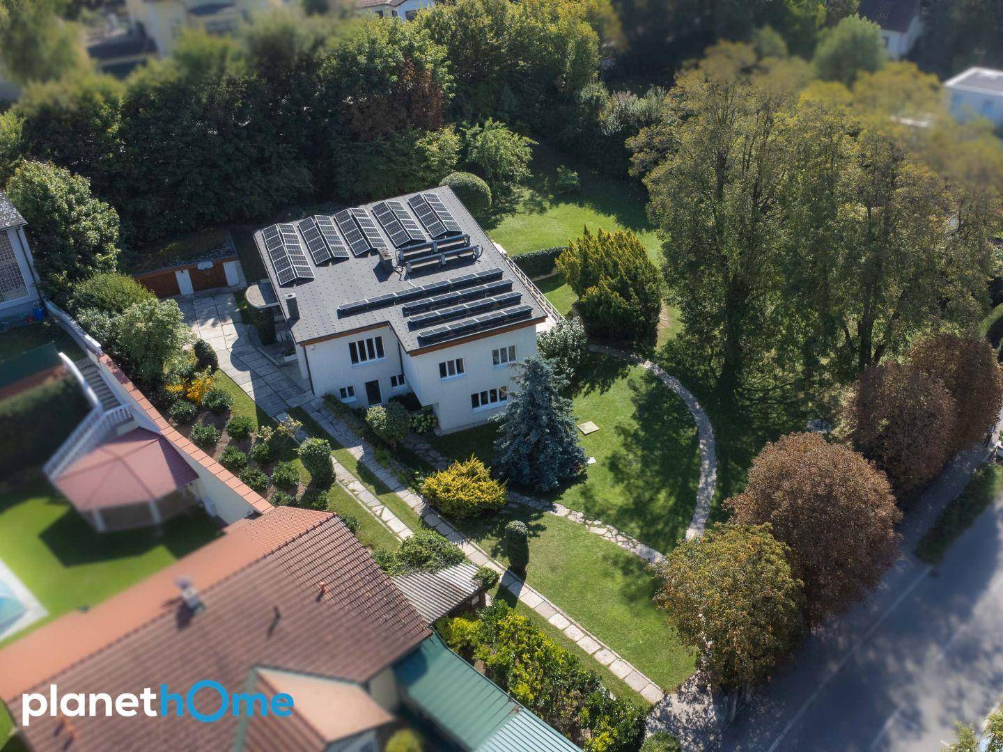 Luftaufnahme des Anwesens mit großem Garten und Photovoltaikanlage auf dem Dach.
