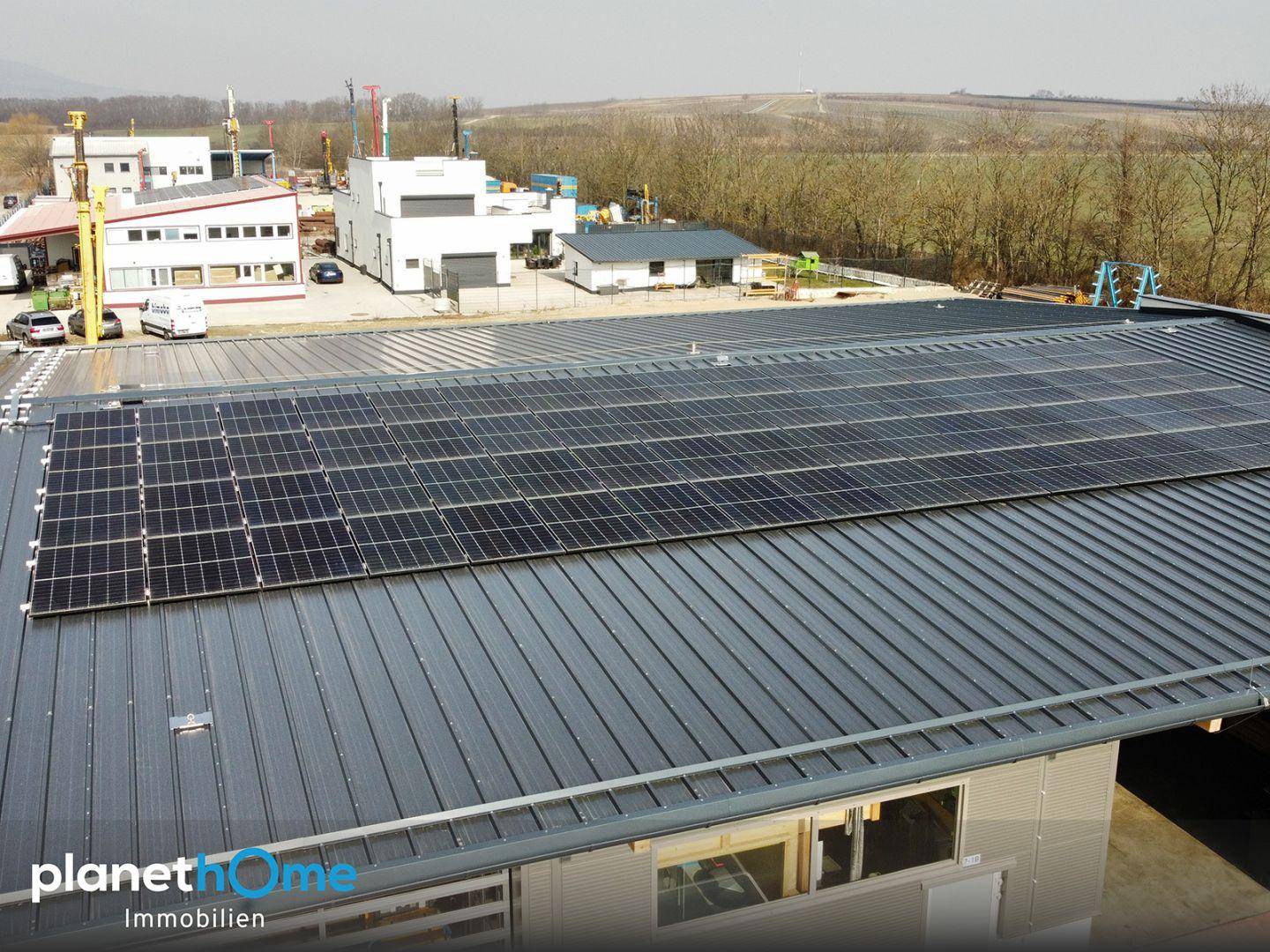 Nahaufnahme des Daches eines modernen Gewerbegebäudes mit installierten Photovoltaik-Modulen zur Energiegewinnung.