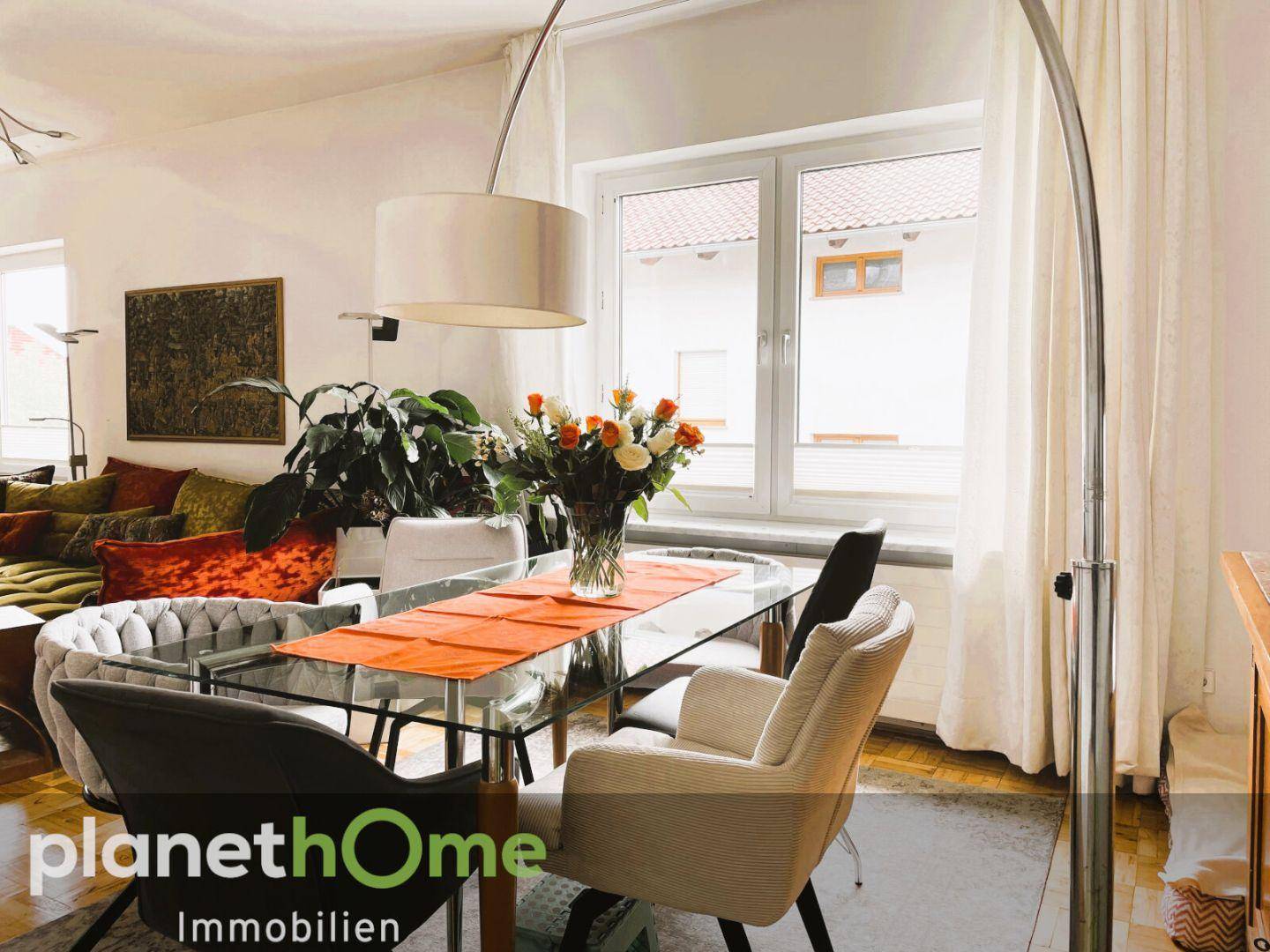 Lichtdurchfluteter Essbereich mit elegantem Glastisch und Blick ins Grüne.