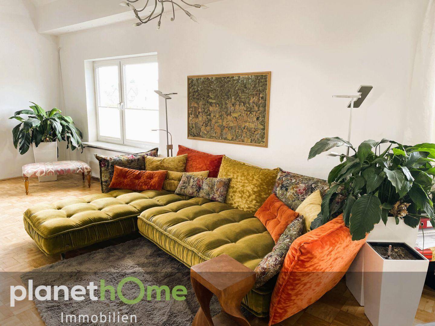 Gemütliches Wohnzimmer mit großem, farbenfrohem Sofa und Parkettboden.