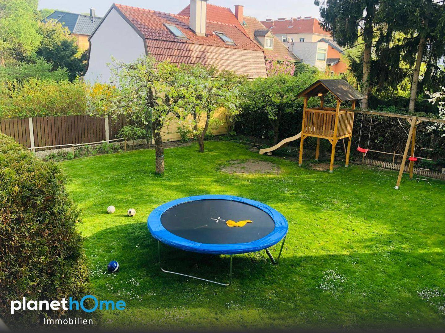 Großer, gepflegter Garten mit Trampolin, Schaukel und Spielhaus für Kinder.