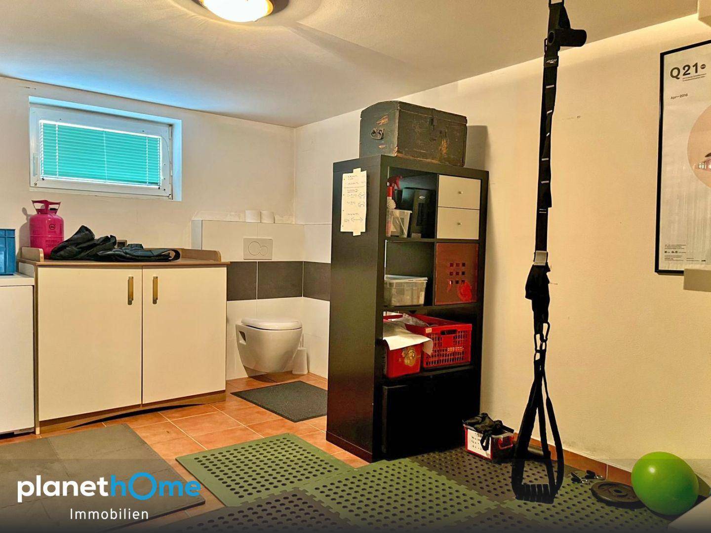 Mehrzweckraum im Untergeschoss mit Toilette, Waschbecken und Stauraum.
