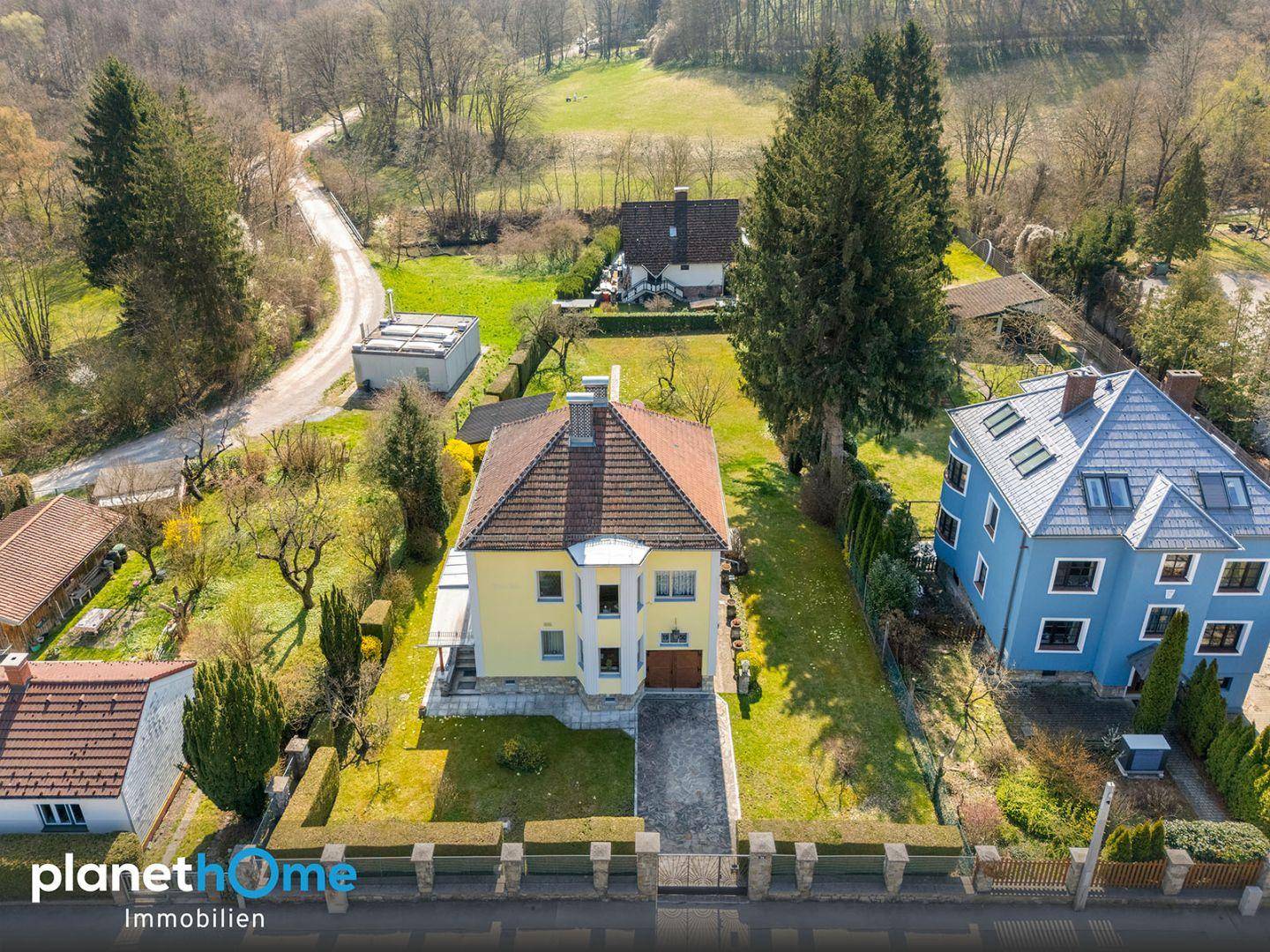 Weitläufige Luftaufnahme des Anwesens mit umliegender Landschaft und Nachbarhäusern.