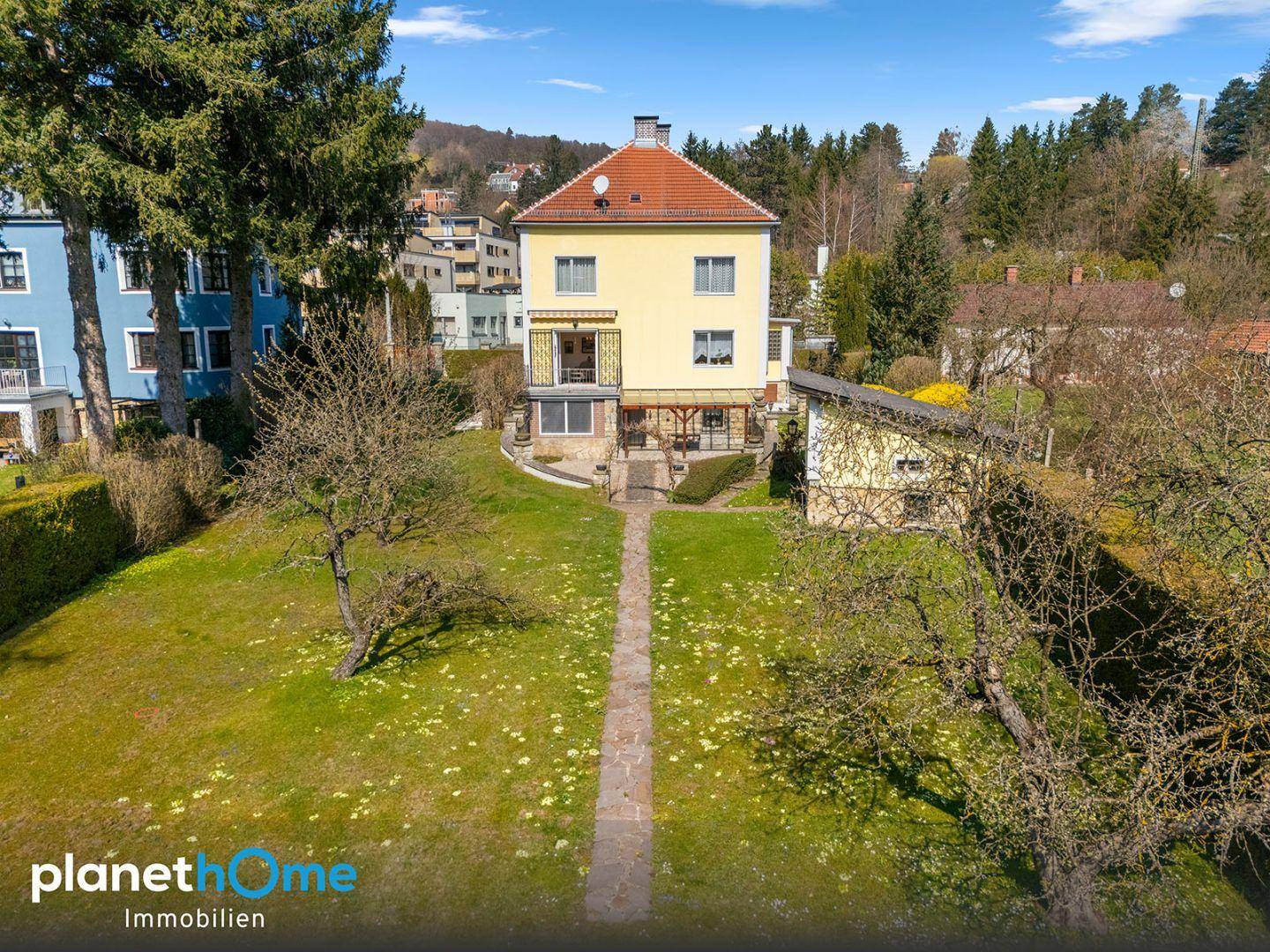 Rückansicht des Hauses mit großem Garten und Blick auf die umliegende Natur.
