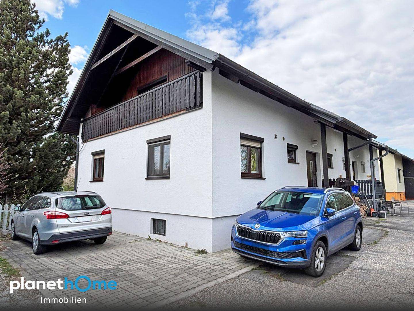 Vorderansicht des Hauses mit gepflasterter Einfahrt und Parkplätzen.