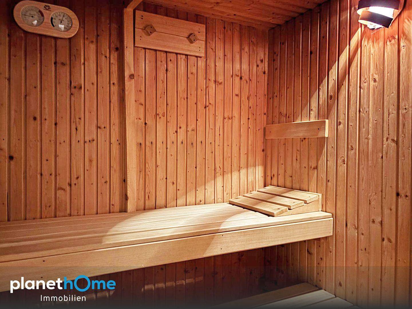 Gemütliche Holzsauna mit Bänken und Temperaturanzeige für entspannende Momente.