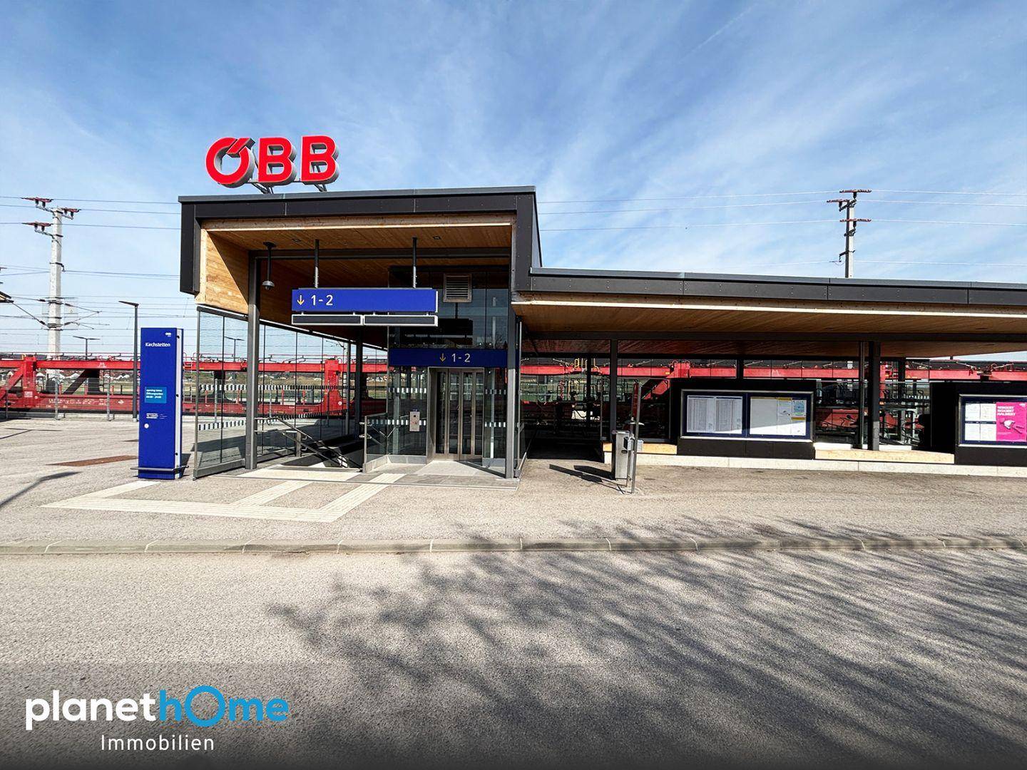 Moderner Bahnhof mit Glasfassade und dem ÖBB-Logo unter klarem Himmel.