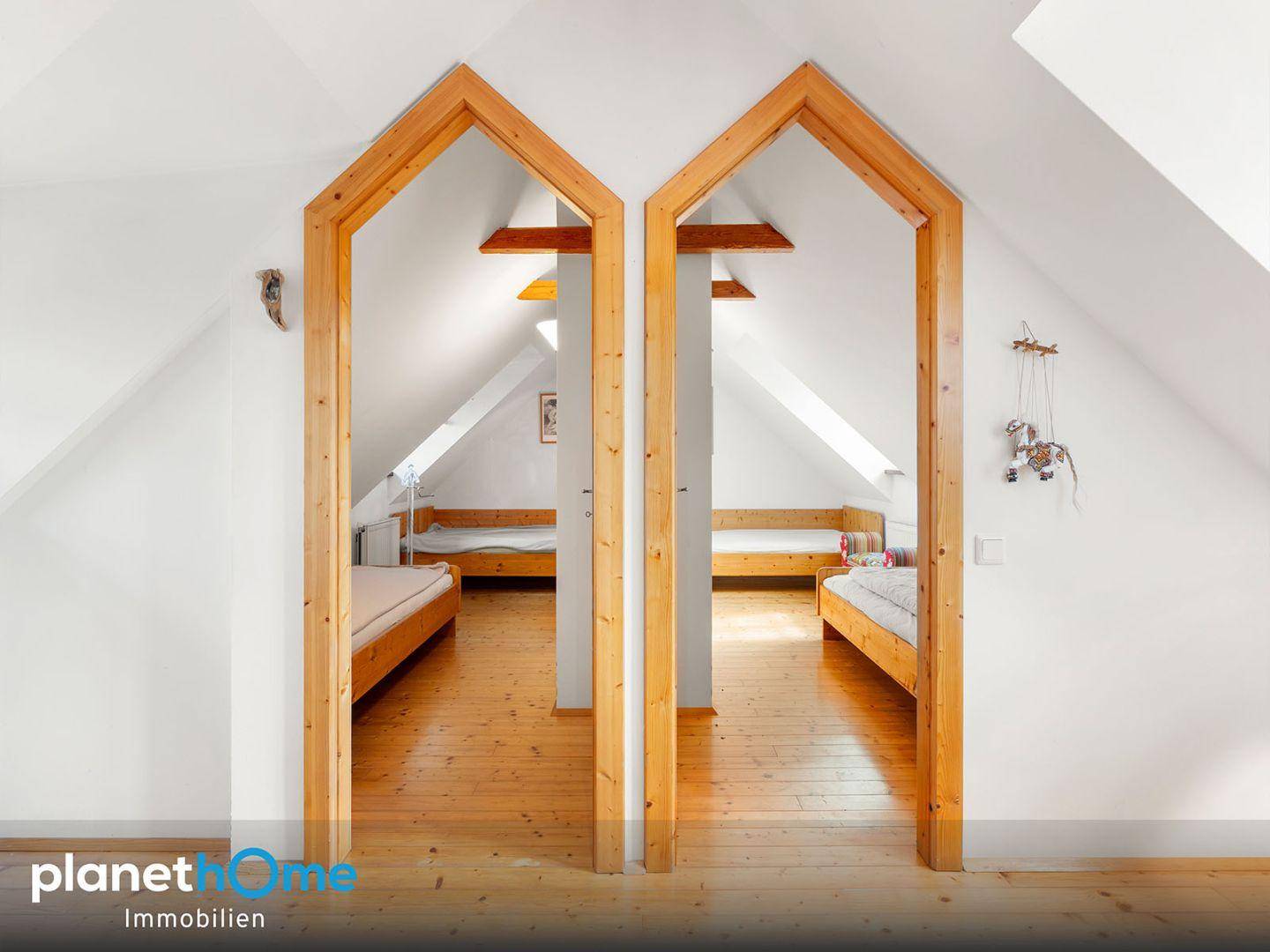 Schlafbereich mit zwei Einzelbetten, Holzboden und Dachschrägen.