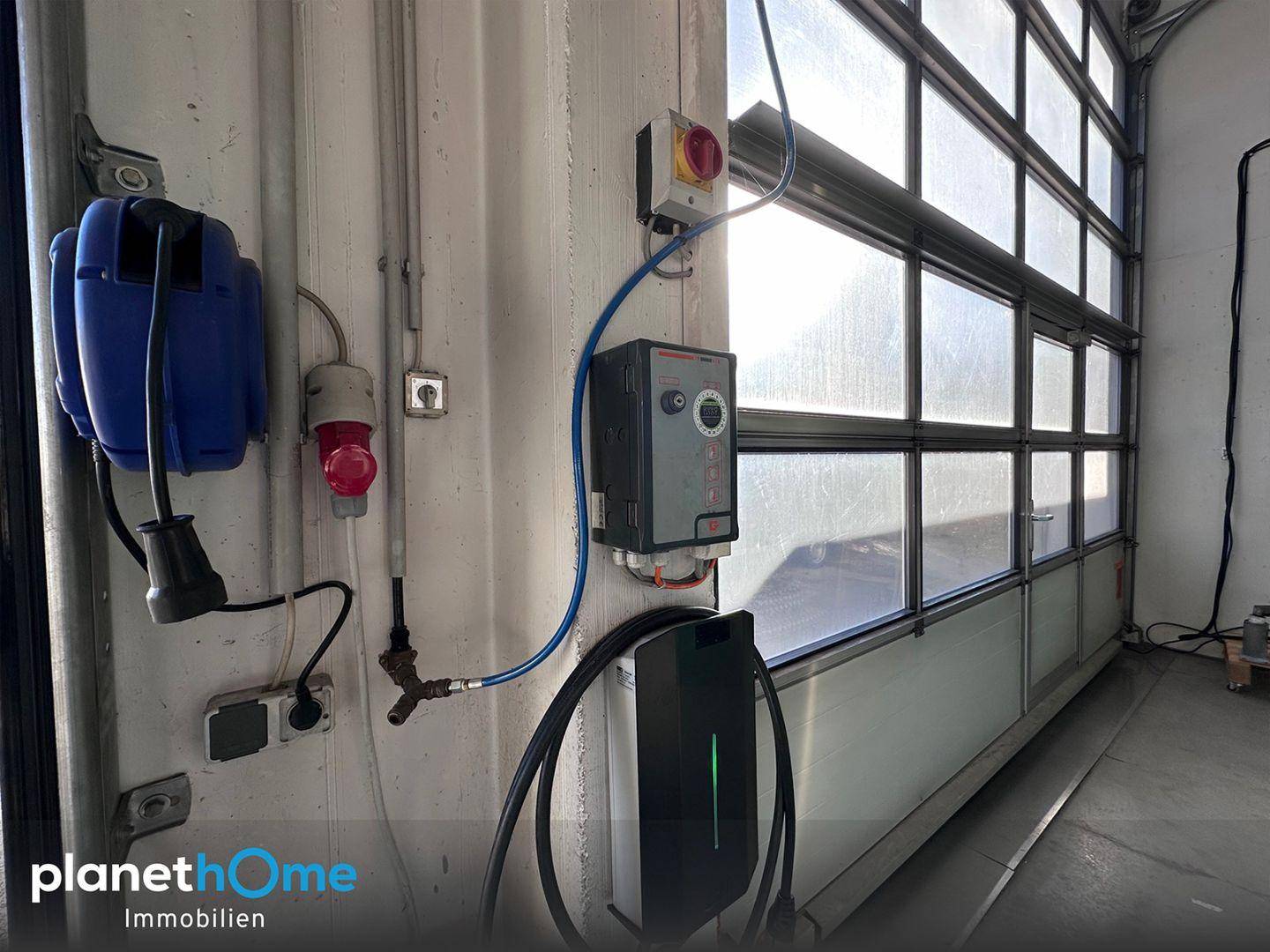 Detailansicht einer Ladestation für Elektrofahrzeuge und weiterer Anschlüsse in der Garage.